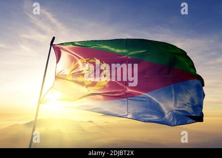 Eritrea Flagge winkt auf dem oberen Sonnenaufgang Nebel Nebel Stockfoto