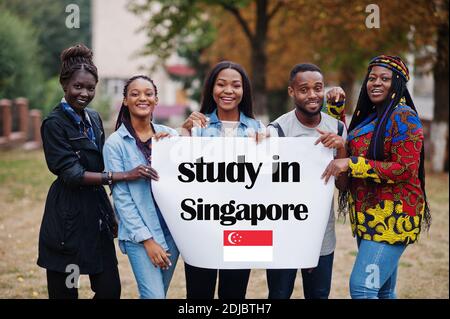 Studieren Sie in Singapur. Gruppe von fünf afrikanischen College-Studenten auf dem Campus an der Universität Hof halten weiß leer. Ausland Länder für Studenten Konzept. Stockfoto