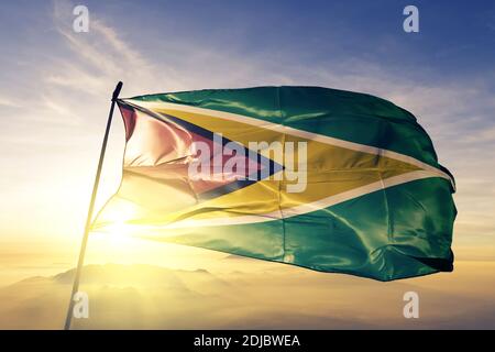 Guyana Flagge winkt auf dem oberen Sonnenaufgang Nebel Nebel Stockfoto