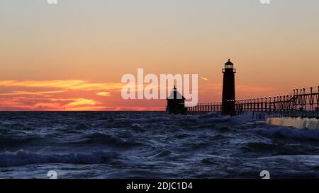 Grand Haven South Pier Leuchtturm bei Sonnenuntergang am Lake Michigan, an einem windigen Tag Stockfoto