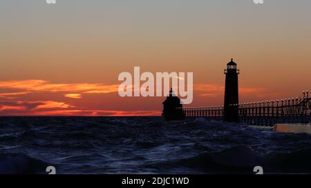 Grand Haven South Pier Leuchtturm bei Sonnenuntergang am Lake Michigan, an einem windigen Tag Stockfoto