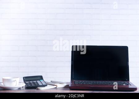 Laptop mit leerem Bildschirm auf dem Schreibtisch. Stockfoto