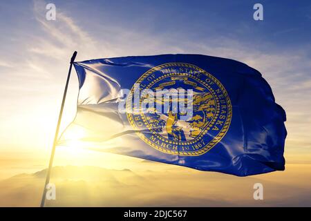 Nebraska State of United States Flagge winkt auf der Spitze nebel bei sonnenaufgang Stockfoto