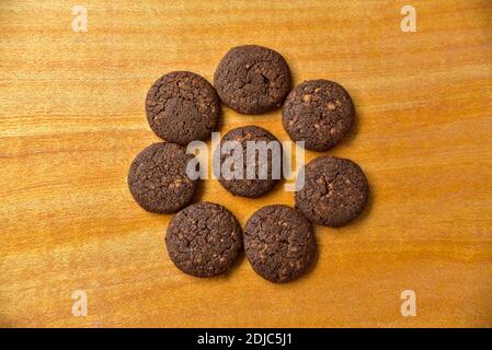 Schokoladenkekse in einem hölzernen Hintergrund. Schokoladenkekse mit Nüssen Draufsicht. Stockfoto