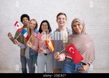 Modernes Austauschprogramm und Sprachenlernen. Glückliche junge internationale Studenten, die die Kamera betrachten Stockfoto