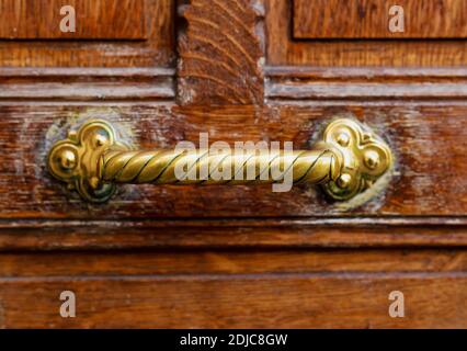 Alter Türgriff an alter brauner Holztür. Nahaufnahme Paris, Frankreich. Goldene Messingdetails an alter Holztür. Griff auf braunem alten Holz schäbig vintage Stockfoto