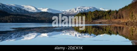 Weit entfernte schneebedeckte Berge spiegeln sich in Loch Beinn A' Mheadhoin, Glen Affric, Schottland Stockfoto