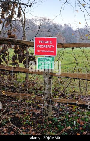 Zwei Schilder auf einem Zaun informieren die Öffentlichkeit 'Privatgrundbesitz und kein Trespassing' Byfleet Surrey England Großbritannien Stockfoto