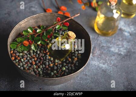 Pistacia terebinthus Öl und getrocknete Samen auf dunklem Holzgrund. Stockfoto