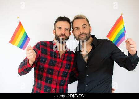 Glücklich Gay Paar hält die homosexuelle Flagge über weißem Hintergrund. Stockfoto