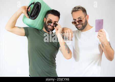 Junge Homosexuell paar von zwei Männern mit Koffer gehen auf Sommerferien über weißen Hintergrund. Stockfoto