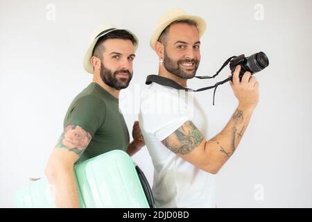 Junge Homosexuell paar von zwei Männern mit Koffer gehen auf Sommerferien über weißen Hintergrund. Stockfoto