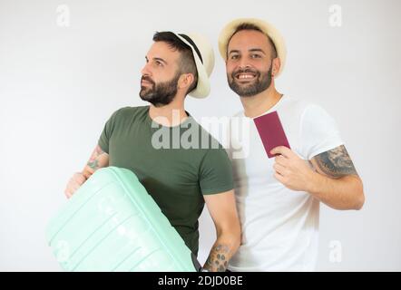 Junge Homosexuell paar von zwei Männern mit Koffer gehen auf Sommerferien über weißen Hintergrund. Stockfoto