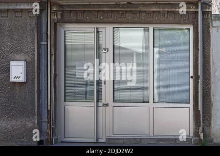 Geschlossene Tür und Jalousien in leerstehenden Laden Stockfoto