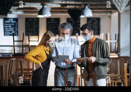 Frustrierter Besitzer, Manager, der mit dem Kellner im geschlossenen Cafe sprach, kleine Geschäfte wurden wegen des Coronavirus geschlossen. Stockfoto