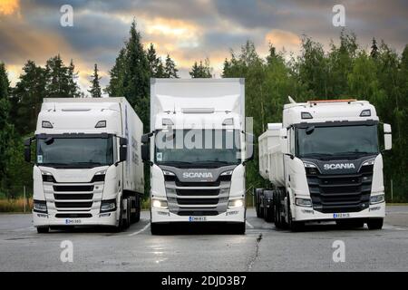 Weiße Scania-Transportwagen, von links R410, Scheinwerfer G500 an, R650 auf Hof geparkt. Scania in Finnland 70 Jahre Tour. Turku, Finnland. August 23, 2019. Stockfoto