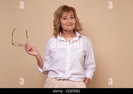 Ziemlich reife Geschäftsfrau mit Brille Blick auf Kamera mit Vertrauen. Studioaufnahme Stockfoto