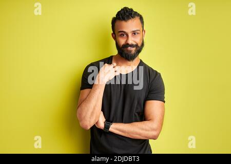 Schüchterner arabischer Mann schaut auf Kamera, fleißiger bärtiger Kerl isoliert auf grünem Hintergrund Stockfoto
