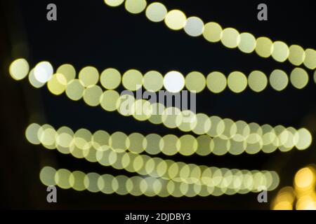 Abstrakter Hintergrund gelb Bokeh Lichter und Zweige eines Baumes im Winter, Weihnachten oder Party-Hintergrund, gemütlich und warm Gefühle Stockfoto
