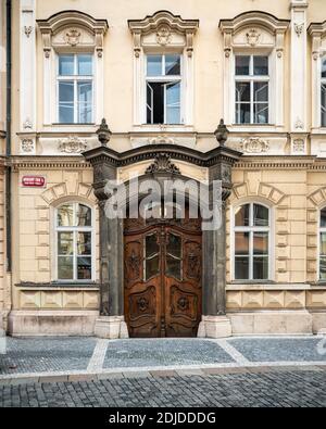 Prager Stadthaus. Eine verzierte Holztür und ein aufwändiger Eingang zu einem typischen Stadthaus in der Altstadt von Prag im Zentrum der Tschechischen Republik. Stockfoto