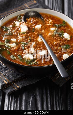 Vegetarische, traditionelle griechische Suppe mit Linsen, die in der Nähe auf einem Teller auf dem Tisch serviert wird. Vertikal Stockfoto