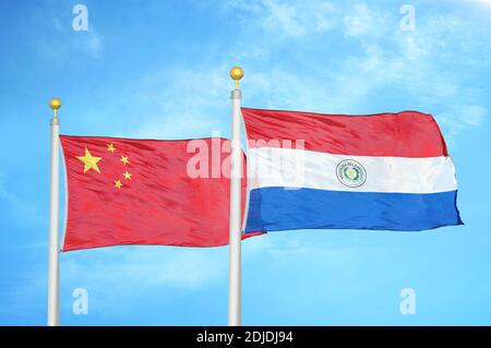 China und Paraguay zwei Flaggen auf Fahnenmasten und blau bewölkt Himmel Stockfoto