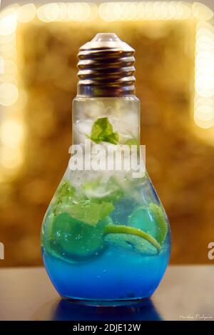 Blaue Lagune Mojito in einem birnenförmigen Glas. Blaue Farbe Limonade mit Eis und Minze Blatt in einem Glas. Stockfoto