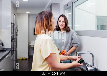 Frauen bereiten gesunde Lebensmittel und Waschen einige Gemüse in der Küche Spaß haben, Konzept Ernährung Ernährung. Stockfoto