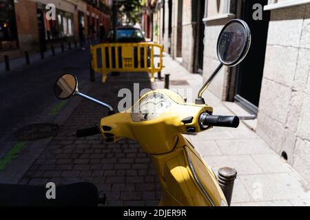 Gelbes Vintage Moped Bike auf einer alten Straße von Madrid An sonnigen Sommertagen Stockfoto