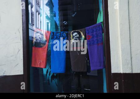 Ein gerahmtes Bild von Che Guevera hängt an einer Mauer gleich neben Tragetaschen in eine Straßenseite Souvenir-Shop. Alt-Havanna, La Habana, Kuba Stockfoto