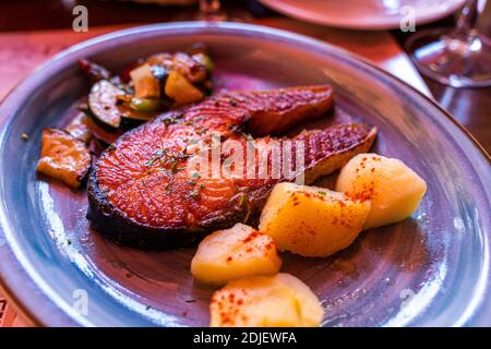 Gegrilltes Steak mit rotem Lachs und gekochten Kartoffeln und Gemüse Auf einer Platte Stockfoto