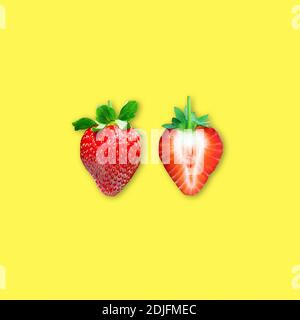 Reife Erdbeere und in Scheiben geschnittene Erdbeeren auf gelbem Hintergrund, Flach minimalistischen Obst essen Foto Stockfoto