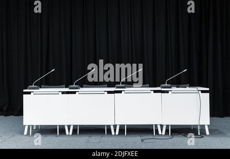Einfarbiges Bild der Konferenz stehen Tisch mit Mikrofonen in einem Besprechungsraum Stockfoto