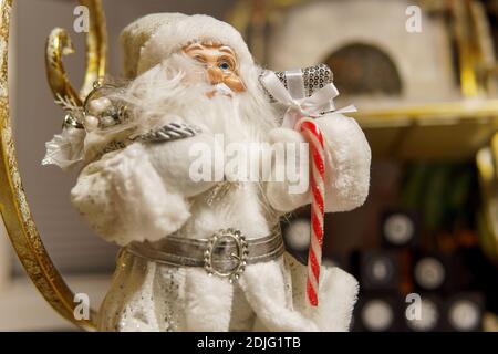 Eine Weihnachtsmann Figur in Nahaufnahme und eine goldene Weihnachten Schlitten im Hintergrund Stockfoto