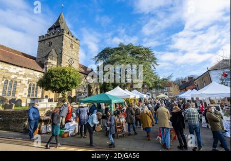 Stände an der beliebten jährlichen Country Brocante Wintermesse im Dezember auf dem Marktplatz von St. Mary Magdalene und St. Denys Kirche, Midhurst, West Sussex Stockfoto