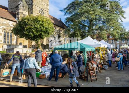 Stände an der beliebten jährlichen Country Brocante Wintermesse im Dezember auf dem Marktplatz von St. Mary Magdalene und St. Denys Kirche, Midhurst, West Sussex Stockfoto