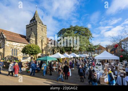 Stände an der beliebten jährlichen Country Brocante Wintermesse im Dezember auf dem Marktplatz von St. Mary Magdalene und St. Denys Kirche, Midhurst, West Sussex Stockfoto