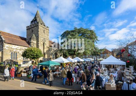 Stände an der beliebten jährlichen Country Brocante Wintermesse im Dezember auf dem Marktplatz von St. Mary Magdalene und St. Denys Kirche, Midhurst, West Sussex Stockfoto