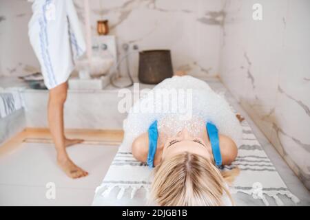 Wunderschöne hübsche Frau, die sich im türkischen Bad im Zimmer ausruhte In Innenräumen Stockfoto