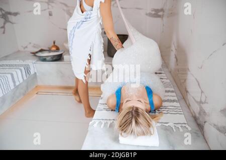 Ziemlich charmante Dame in blauen Bikini genießen tolle Zeit während Türkisches Bad Stockfoto