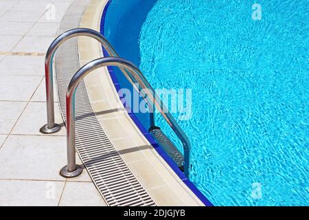 Schnappen Sie sich Bars Leiter im blauen pool Stockfoto