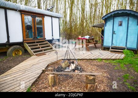 Camping in einem Wald mit umgebauten Zugwagen in Gloucestershire, England Stockfoto