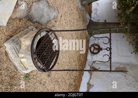 Alte veraltete Brunnen aus Stein und Eisen. Stockfoto