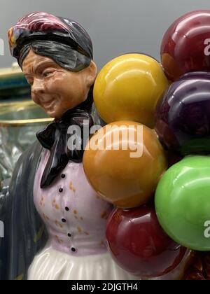 Eine vertikale Aufnahme einer alten Frau Porzellanfigur halten Ballons Stockfoto