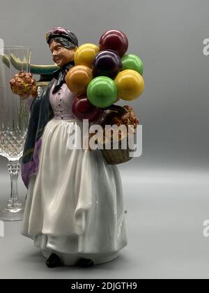 Eine vertikale Aufnahme einer alten Frau Porzellanfigur halten Ballons Stockfoto