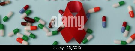 Word Hilfe wird von weißen Pillen vor dem Hintergrund der gemacht Viele bunte Kapseln und ein rotes Band Stockfoto