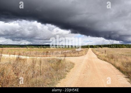 Kreuzung mit schwarzen Wolken im Hintergrund schneiden den Himmel. Stockfoto