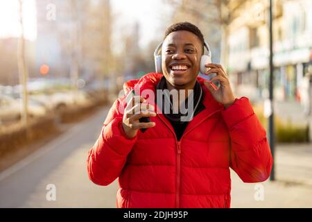 Junger Mann mit Kopfhörern und Musik hören in der Stadt Stockfoto