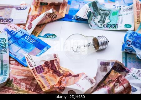 Faltiges russisches Geld, Glühbirne und Kalender, Lampe und Geld, zerknittertes Geld Stockfoto