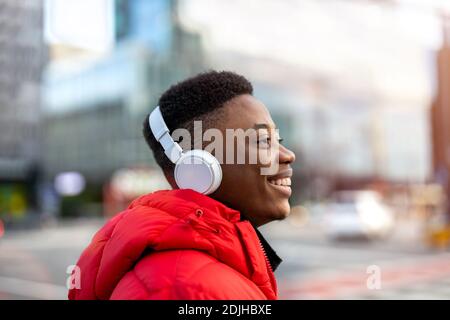Junger Mann mit Kopfhörern und Musik hören in der Stadt Stockfoto